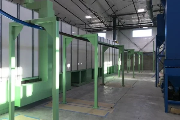 Conveyor running alongside a green and white washer housing