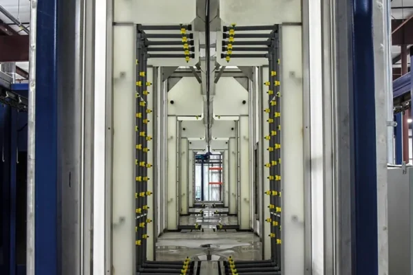 Washer tunnel interior with staged spray risers on both sides